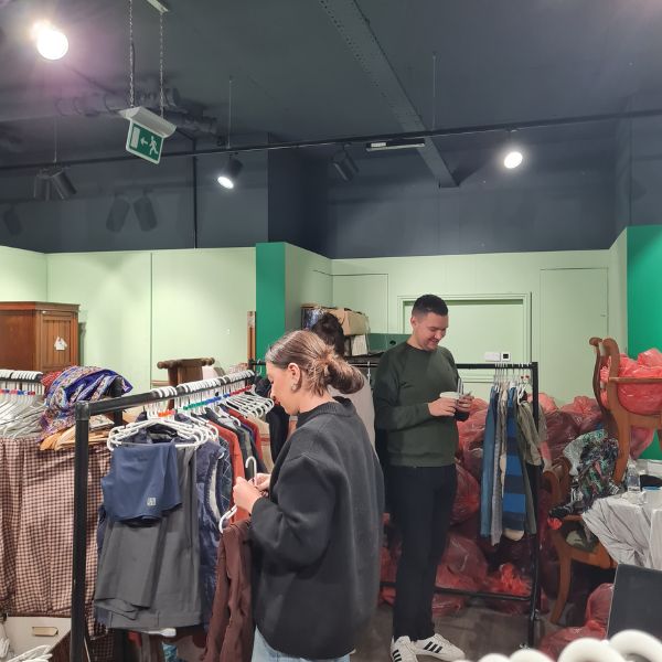 Hanging and pricing clothing donations at HITW retail shop