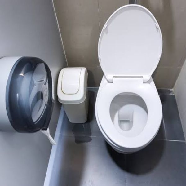 Bathroom stall with sanitary waste bin next to toilet